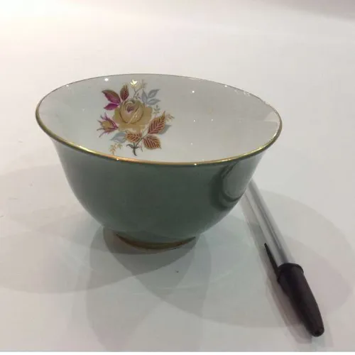 ceramic bowl teal outside, flower design inside and gold trim
