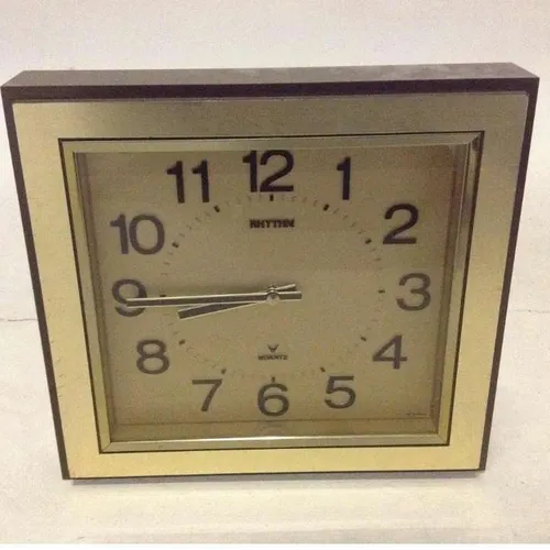 Rhythm analogue gold coloured period wall clock with plastic face and brown plastic rim