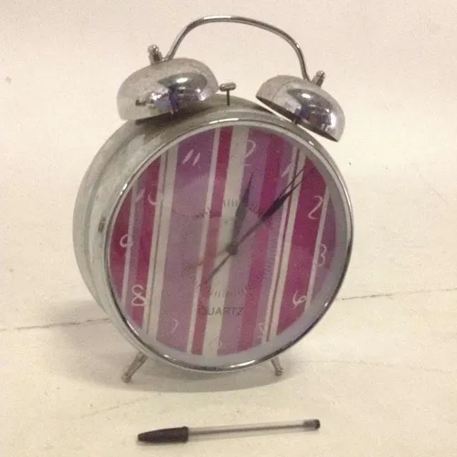 silver metal analogue twin bell alarm clock with pink and white stripped face
