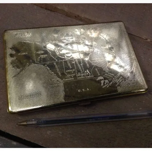 gold metal cigarette case with map of Canada design