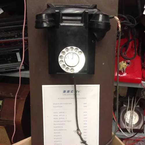 black corded rotary dial telephone mounted on board