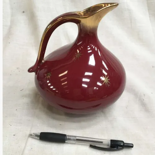 Glazed red jug with gold spout and star detail