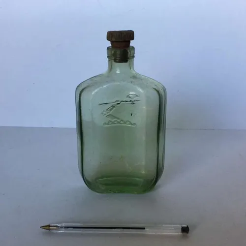 period green glass flat sided bottle with with weapon embossing