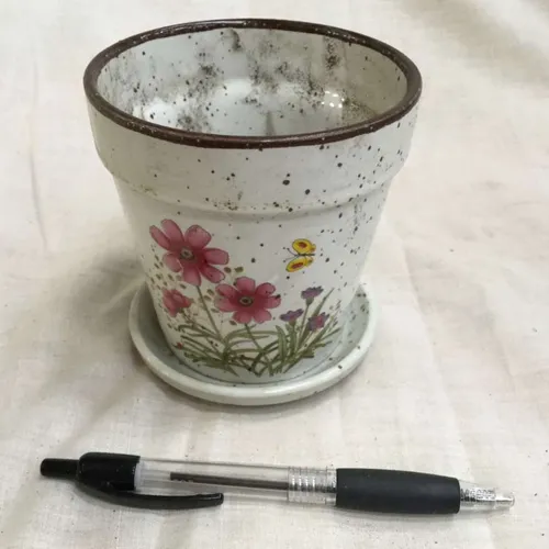 white speckled plant pot with painted flower decoration