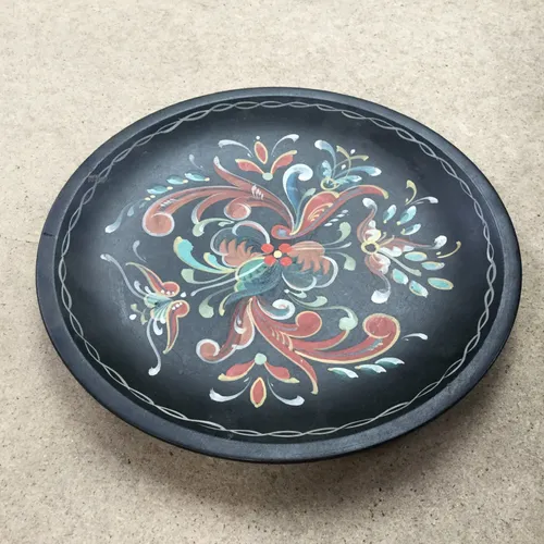 Black plate with floral painted decorative detail 