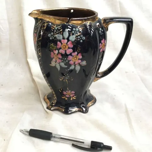 Black jug with floral detail and gold trim