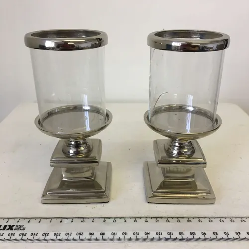 Pair of silver pedestal pillar candle holders with glass sleeve