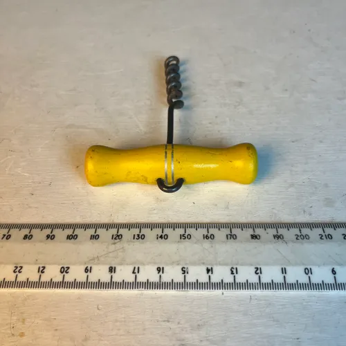 Old corkscrew with yellow handle