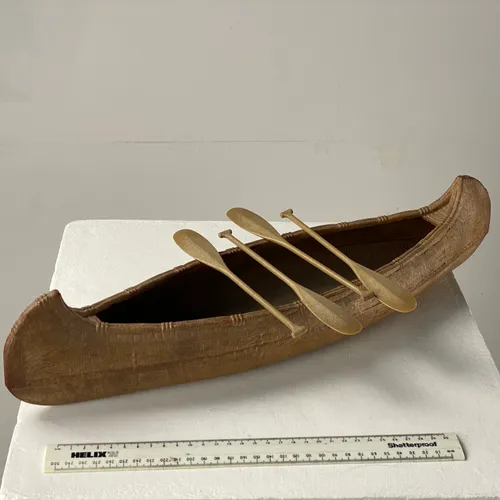 Brown Toy canoe with paddles