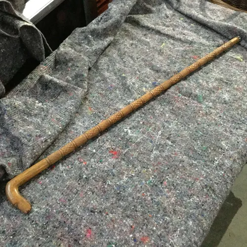 Light wood walking stick with carved detail 
