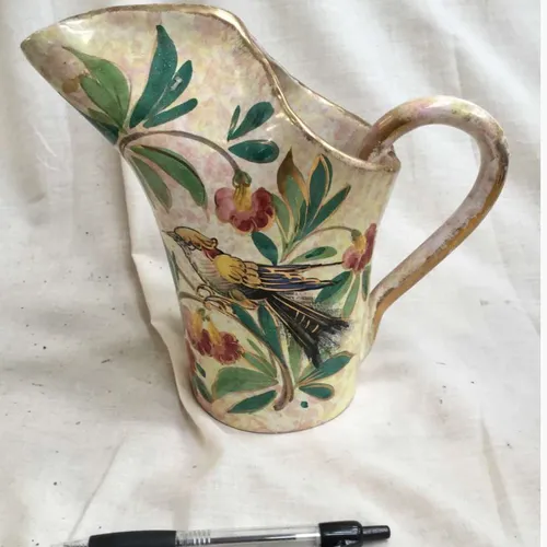 Jug with painted flower and bird detail and tall spout