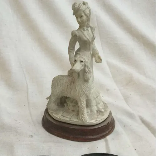 Woman with dog ornament on wood base