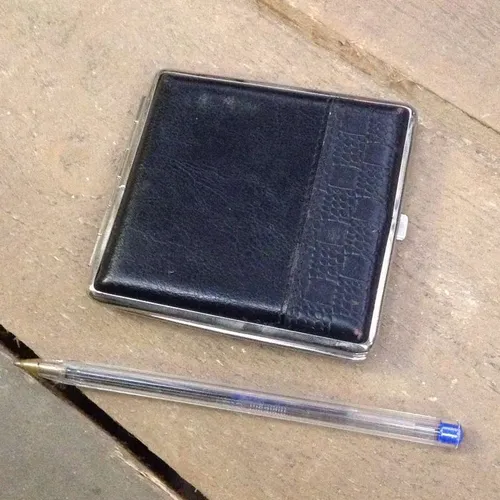 silver cigarette case with black cover