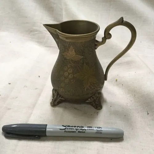Small brass jug with grapevine detail and engraved feet