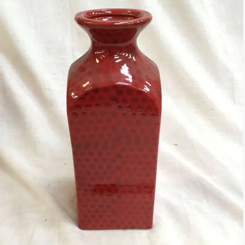 Tall red glazed ceramic vase with square base and subtle pattern