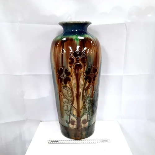 Tall glazed brown, green and blue vase with flower design