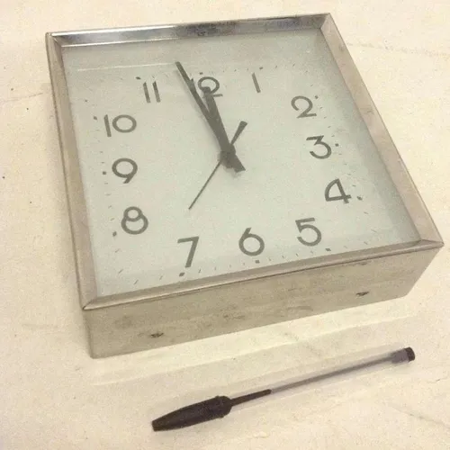 silver metal analogue wall clock with white face and glass face cover