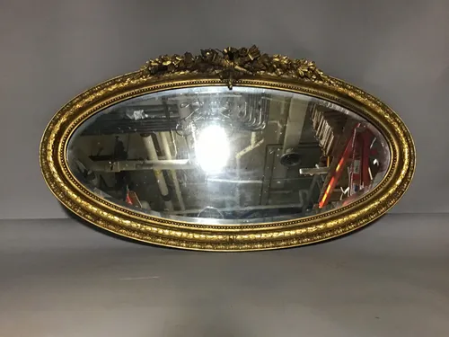 vintage oval gold mirror with laurel leaves at top 