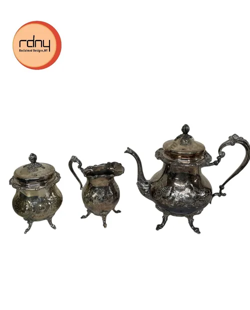 ornate silver coffee/tea pot with cream and sugar bowls