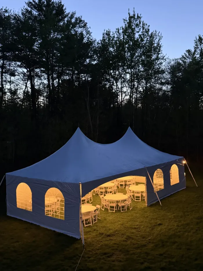 20x40 high peak frame tent with sidewalls, round tables, and resin chairs.