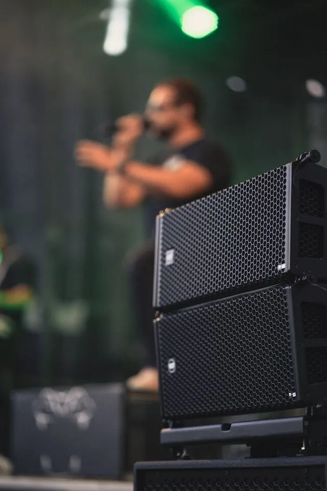Speakers on stage with MC on microphone in the background.