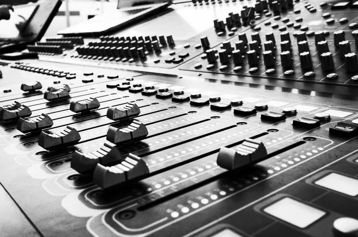 Audio mixing console and laptop set up to control sound at a live event.