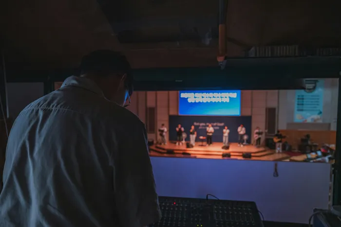 Sound technician checking an audio mixing console before a live event.