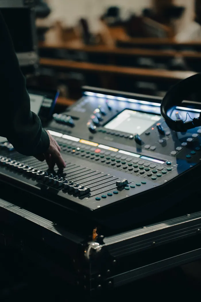 Sound engineer operates mixing desk in Adelaide.