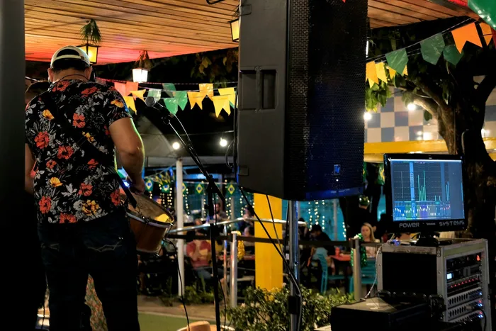 ProPfessional PA speaker elevated on a tripod stand for improved sound coverage at an event.