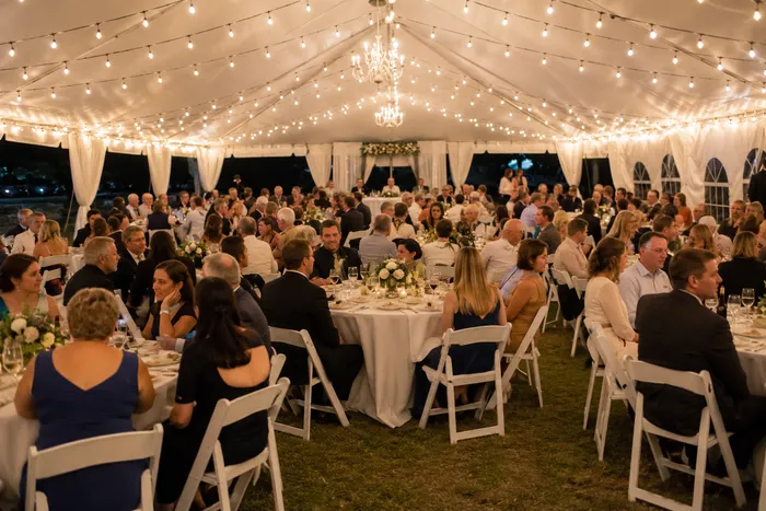 Guests seated at rented tables and chairs during an outdoor event with comfortable spacing and professional event setup.